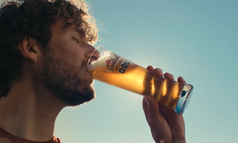Man drinkt Grolsch Weizen 0.0% in het zonnetje